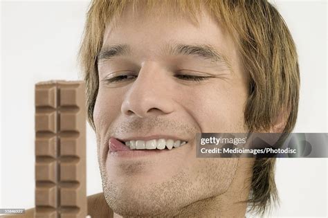 Young Man Licking His Lips And Looking At Chocolate Candy Bar Photo Getty Images