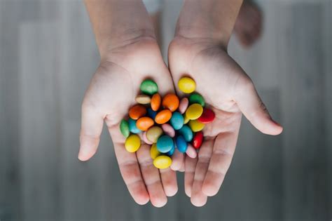 Premium Photo A Child Holding A Handful Of Candy