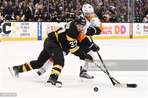 Patrice Bergeron Of The Boston Bruins Fights For The Puck Against