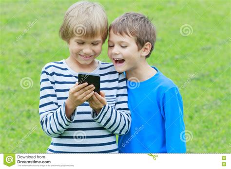 Boys With Mobile Phone Children Smiling Looking To Screen Playing