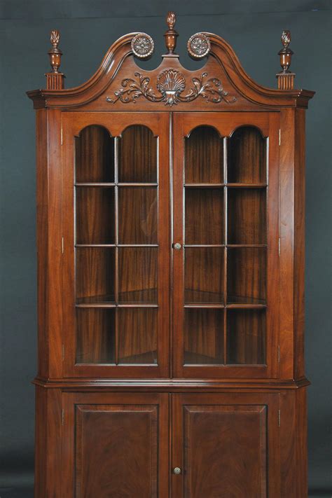 A a wall cupboard used for storage, as of kitchen utensils or toilet articles: Colonial Style Corner Cabinet with Carved Arch