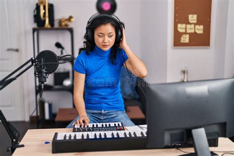 Young Chinese Woman Musician Playing Piano Keyboard At Music Studio