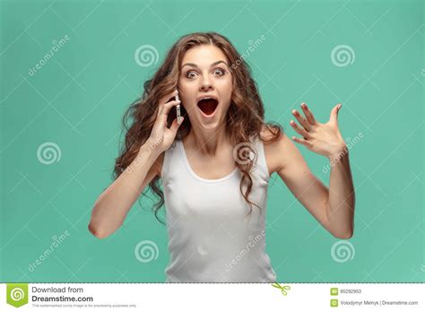 Shocked Woman Looking At Mobile Phone On Green Background Stock Image