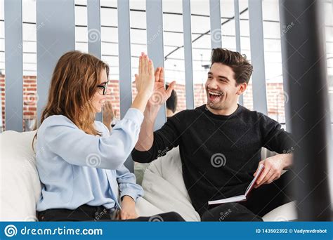 Cheerful Young Couple Of Colleagues Working Together Stock Photo