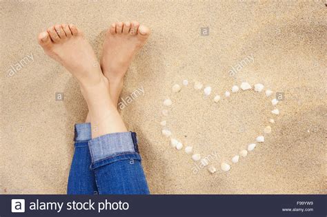 Female Feet Closeup Of Woman Standing At The Sandy Beach Next To The