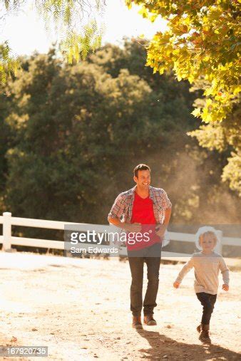 Father Chasing Son On Dirt Road High Res Stock Photo Getty Images