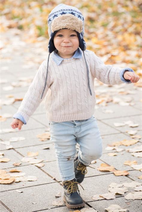 Beautiful Baby Boy Walking Throw The Autumn Leaves At The Park Stock