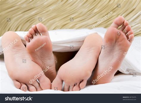 Image Of Two Pairs Of Bare Male And Female Feet During Sleep Stock