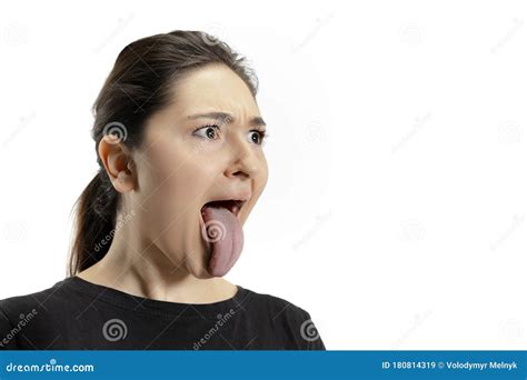 smiling girl opening her mouth and showing the long big giant tongue isolated on white