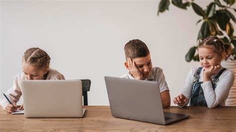 Niños Que Usan Computadoras Portátiles En La Escuela Foto Gratis