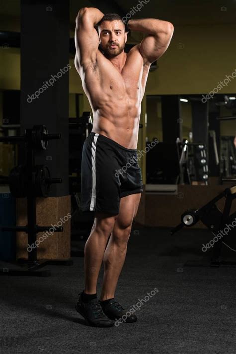 Handsome Muscular Man Flexing Muscles In Gym — Stock Photo © Ibrak