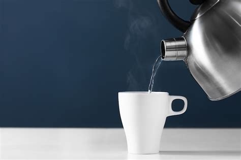 Pouring Hot Water Into Into A Cup On A Dark Background Photo Premium Download
