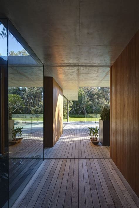 The Inside Of A House With Wooden Floors And Large Glass Doors Leading
