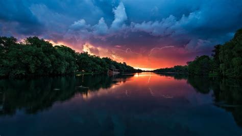 Sunset Peaceful River Coast With Green Trees Forest Red