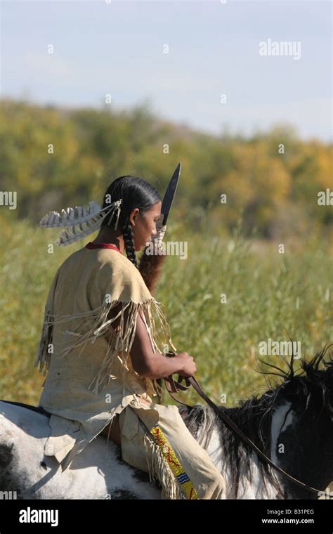 A Native American Sioux Indian Boy On Horseback Riding Across A Stream