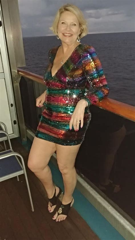 A Woman Is Standing On The Deck Of A Cruise Ship Wearing A Colorful Sequin Dress