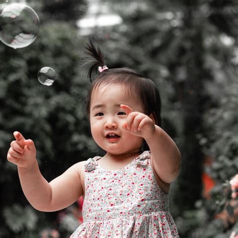 Premium Ai Image A Little Child Playing With Bubbles