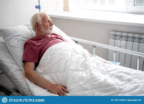 Patient Lying In Hospital Bed And Looking Out The Window Stock Image