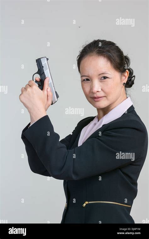 Portrait Of Woman In Business Suit Holding A Hand Gun With Agent Pose
