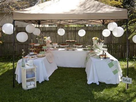 A Table Set Up With Plates And Desserts Under A Canopy In The Grass