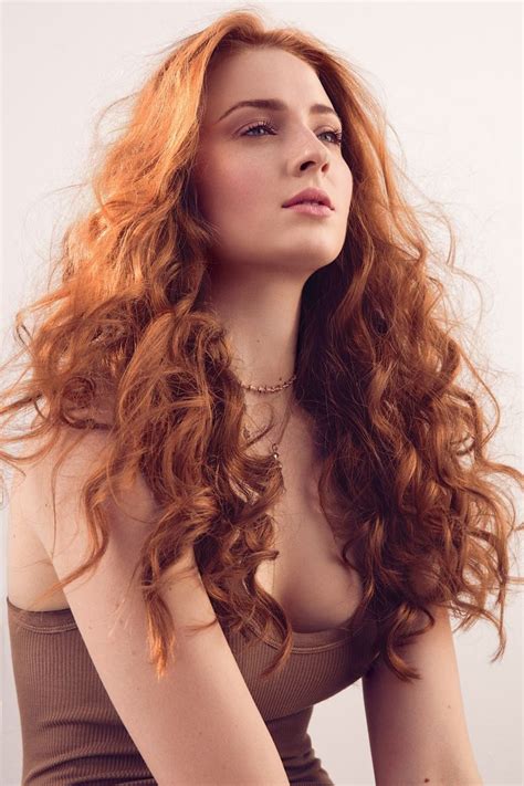 A Woman With Long Red Hair Is Posing For The Camera