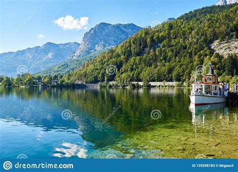 Beautiful Landscape With Lake Boat Mountain Forest And Reflection On
