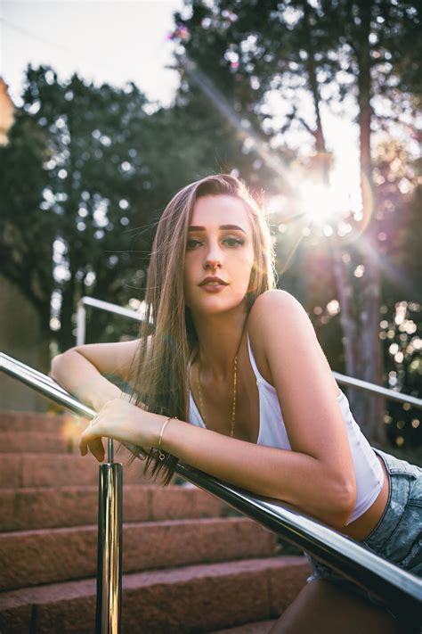 Young Woman Leaning On Railing In Park · Free Stock Photo