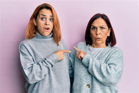 Latin Mother And Daughter Wearing Casual Clothes Surprised Pointing With Finger To The Side