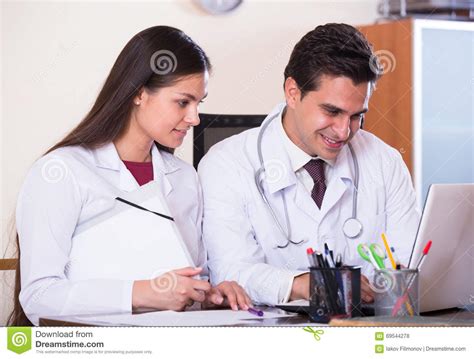 Doctor Consulting Young Intern In Clinic Office Stock Photo Image Of