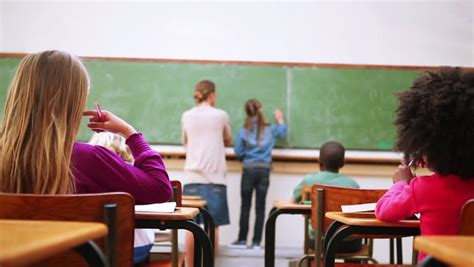 Cute Pupil Writing On The Blackboard In The Classroom Stock Footage