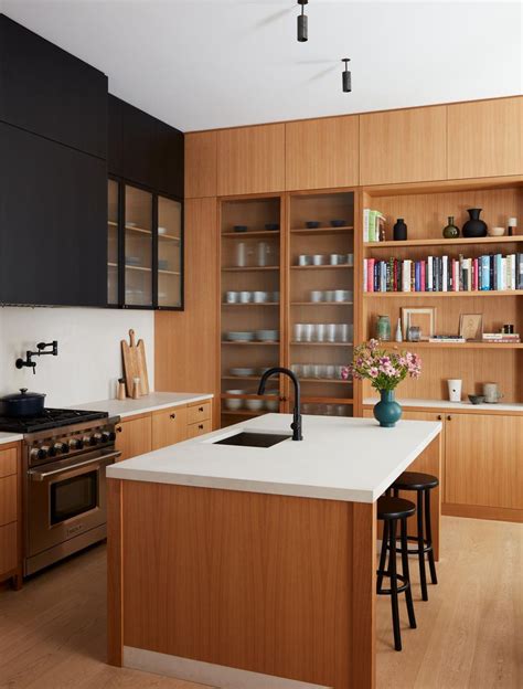 A Kitchen With Wooden Cabinets And White Counter Tops Next To An Island