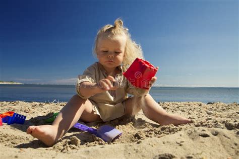 使用在海滩的沙子的小女孩由海 库存照片 图片 包括有 生活方式 海岸 城堡 本质 异乎寻常 纵向
