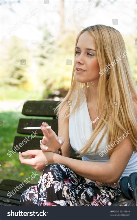 Young Woman Smoking Cigarette Outdoors Stock Photo