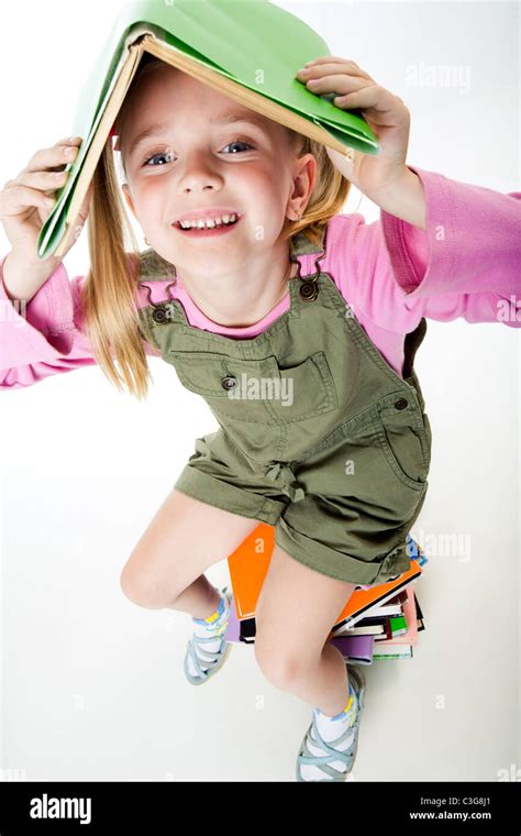 Image Of Pretty Young Girl Under Book In The Studio Stock Photo Alamy