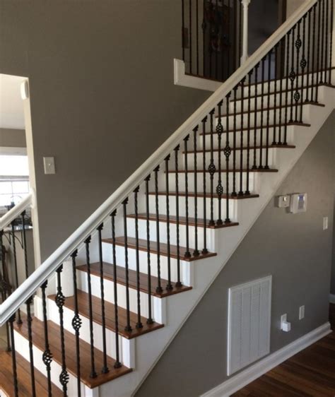 Gorgeous wood and iron staircase boasts mixed iron spindles complementing an iron handrail and light wood treads. Wrought Iron Banister | Stair Designs