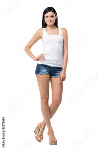Full Length Portrait Of A Brunette Woman Who Is In A White Tank Top And