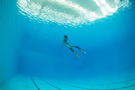 Female Freediver Swimming Underwater In Swimming Pool By Stocksy