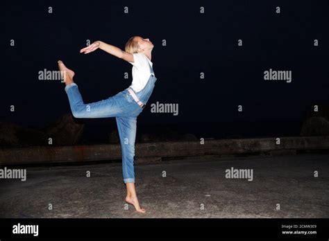 Barefoot Teenage Girl Dancing Ballet On An Empty Pier At Night Stock
