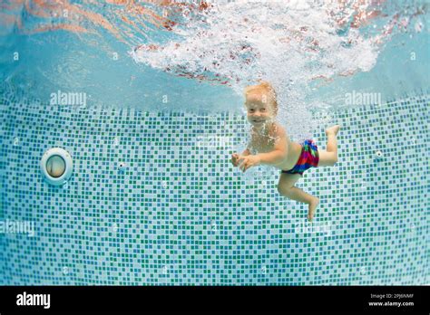Funny Portrait Of Child Learning Swimming Dive In Blue Pool With Fun