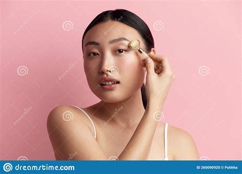 Face Massage Sensual Asian Woman Using Jade Facial Roller For Skin