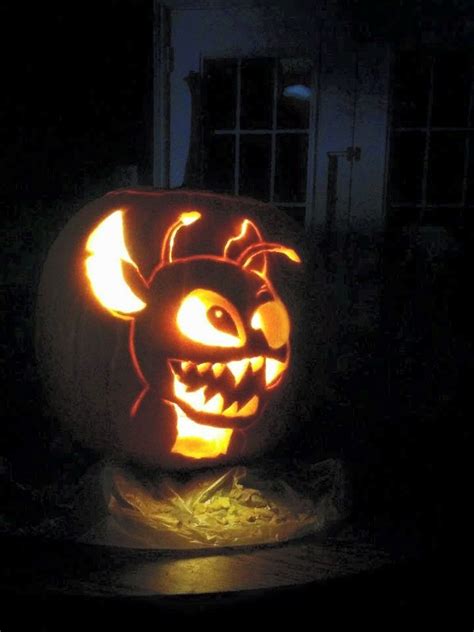 A Pumpkin Carved To Look Like A Bat With Glowing Eyes And Fangs On Its