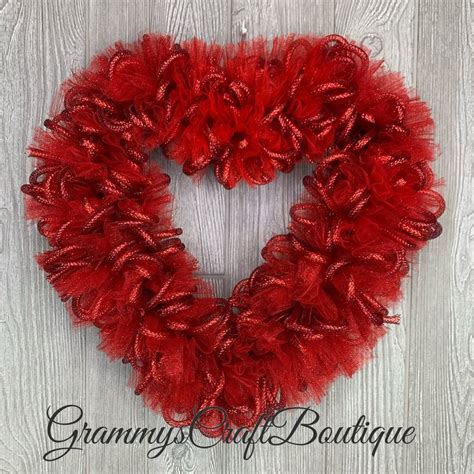 A Red Heart Shaped Wreath Hanging On The Wall