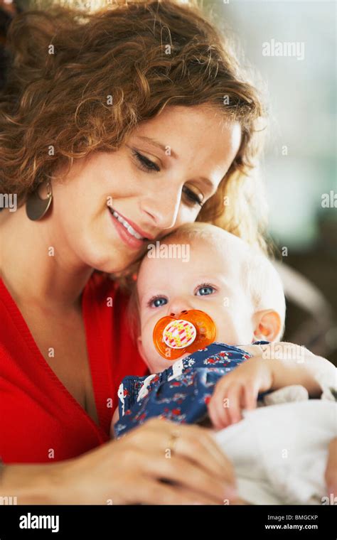 A Mother Cuddling With Her Infant Stock Photo Alamy
