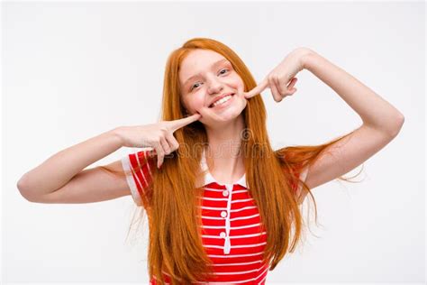 Positive Redhead Young Woman Touching Her Cheeks With Fingers Stock