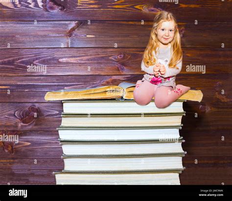 Little Girl Sitting On Stack Of Books Stock Photo Alamy