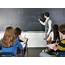 Teacher Writing On Chalkboard In Classroom  Stock Photo Dissolve