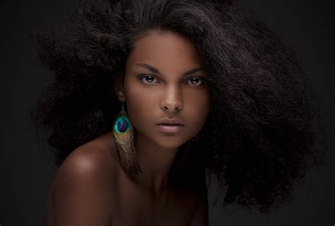 Фото Красивая темнокожая девушка с серьгой в виде пера By Hart Worx