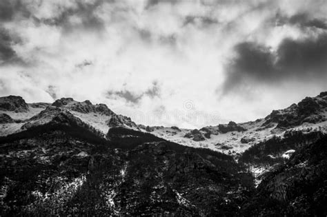 Dramatic Black And White Snowy Mountain With Strong Clouds Over It