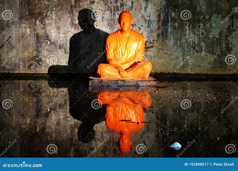 Statue Of Orange Monk Sitting In A Cave Editorial Photography Image