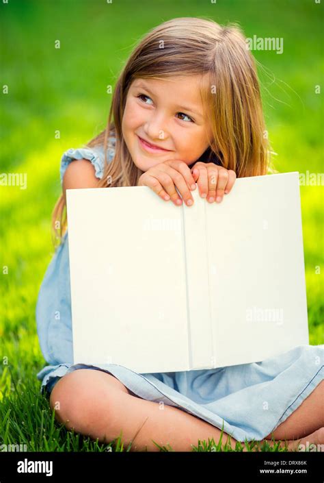 Adorable Cute Little Girl Reading Book Outside On Grass Stock Photo Alamy